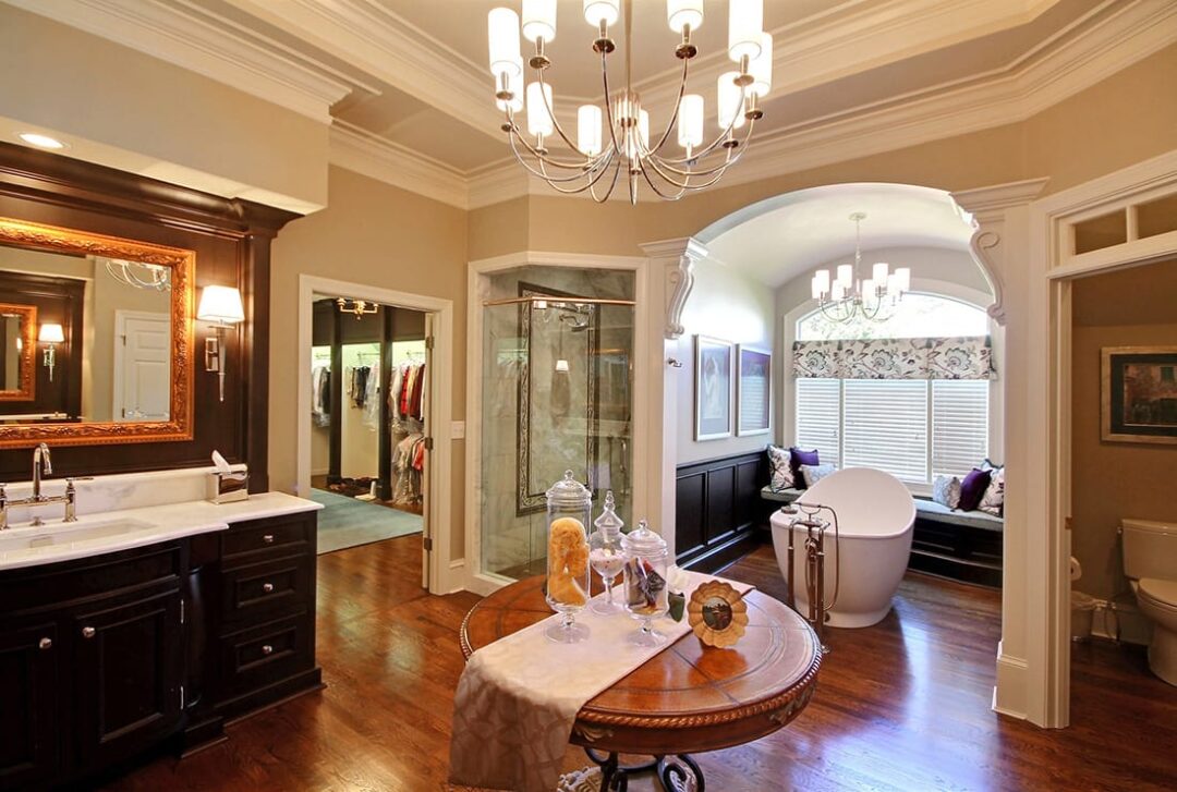 Elegant dark wood master bath remodeling featuring a chandelier and a luxurious tub in Norcross, GA